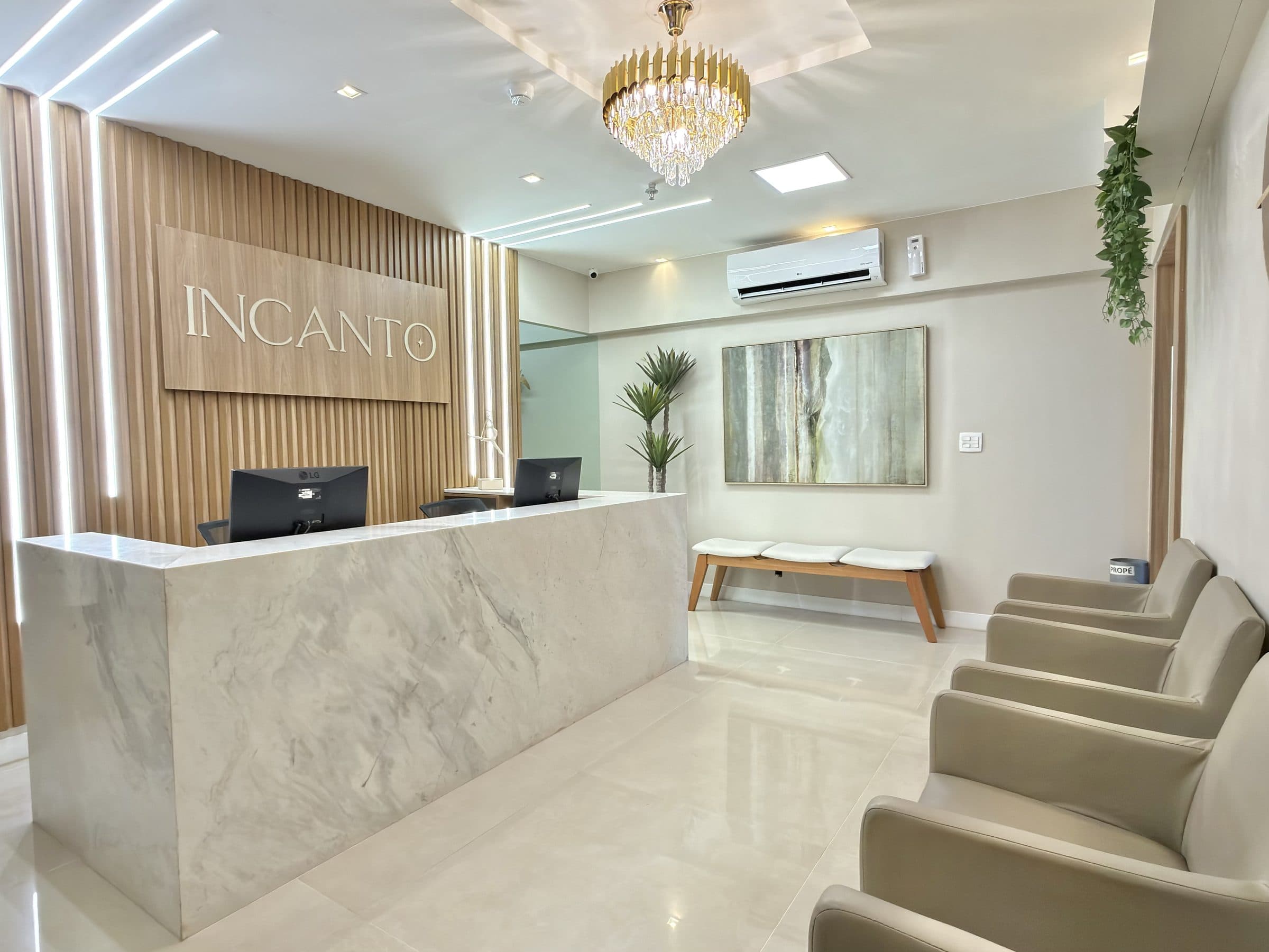 Recepção da Clínica Incanto, com lustre e balcão de mármore